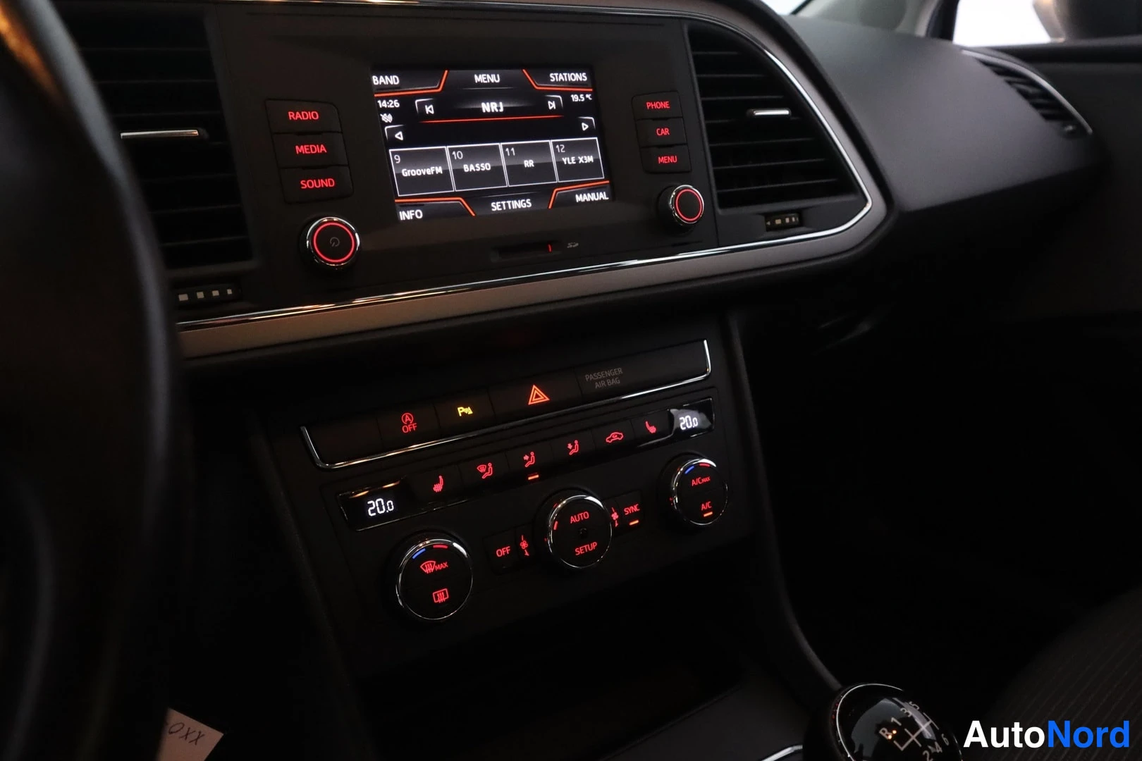Ohjaamo: Dashboard with infotainment screen showing NRJ radio station in display. Below, automatic climate control with digital temperature readouts set to 20.0 degrees