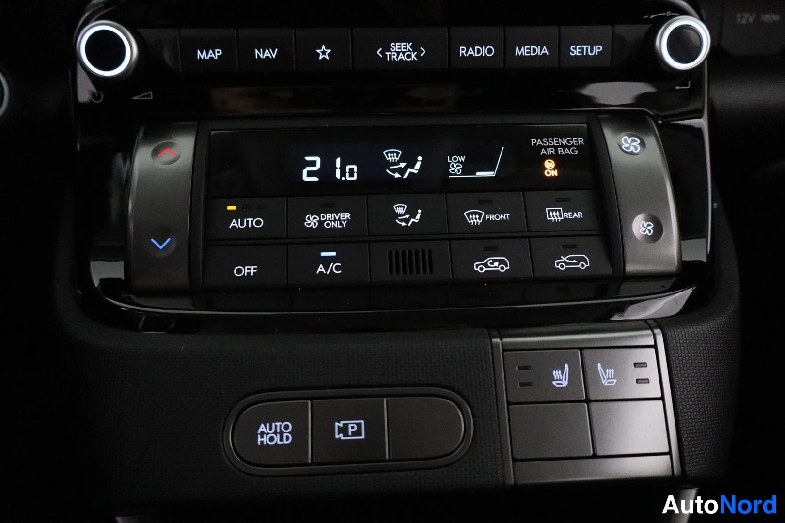 Muu: Keskiö console: ilmastointipaneeli (21,0 °C, AUTO, A/C) ja lämpöistuinten ja Auto Hold- ja elektronisen jarrun painikkeet.