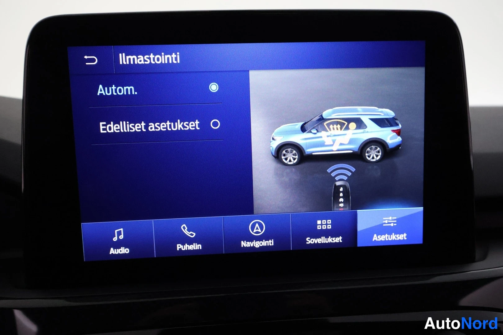 Edestä: Auton kojelaudan infotainment-näyttö, jossa on avoinna ilmastoinnin asetusnäkymä.