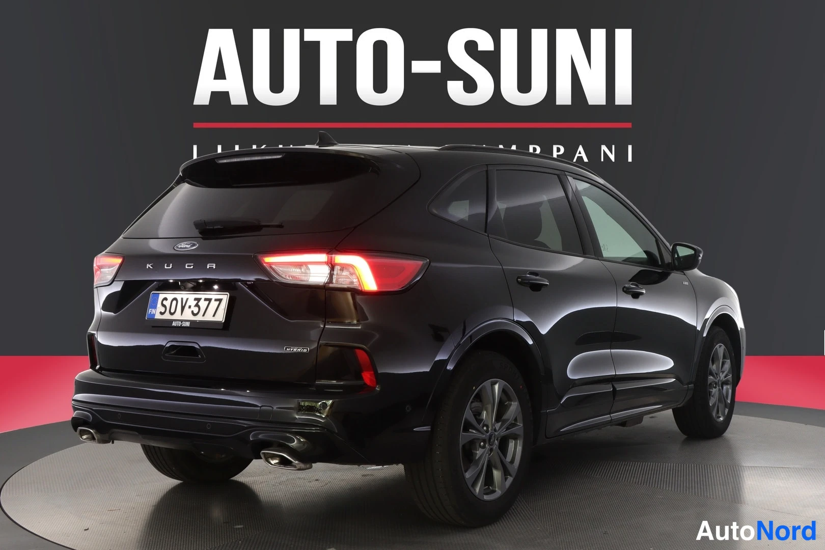 Takaviisto: Musta Ford-auto takaa hieman oikealta katsottuna. Takavalot on sytytetty, ja rekisterinumero on selkeästi luettavissa.