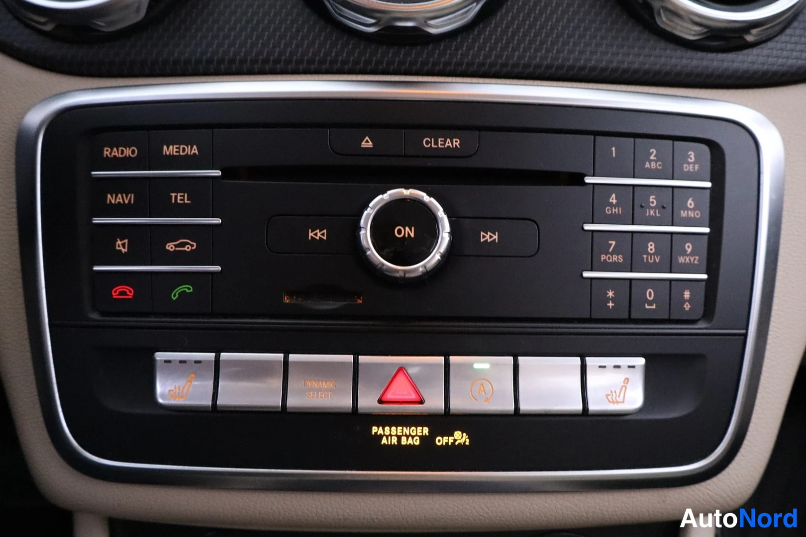 Etuviisto: Mercedes-Benzin keskikonsoli: radio-, media- ja navi-painikkeet, numeroit näppäimistö sekä lämmitettävien istuinten painikkeet.