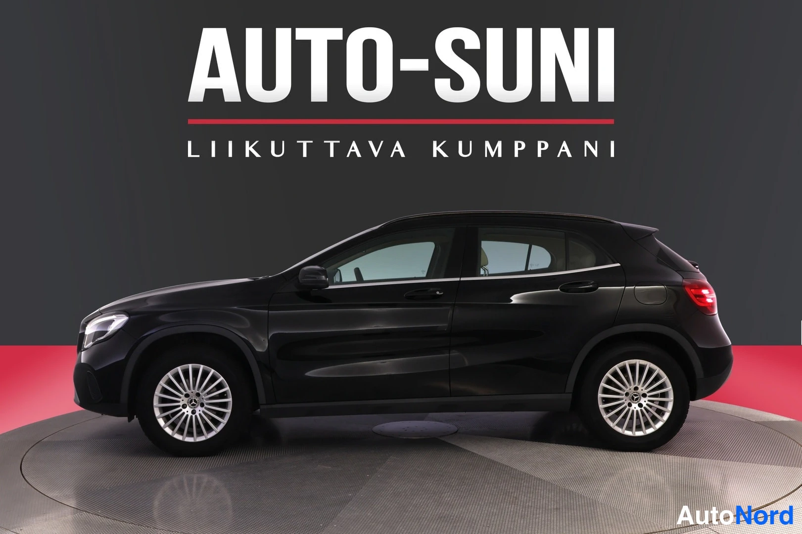 Etuviisto, nokka vasemmalle: Mustan Mercedes-Benz GLA -maasturin kylki etukulmasta, nokka kuvan vasemmassa laidassa, hopeavanteet.