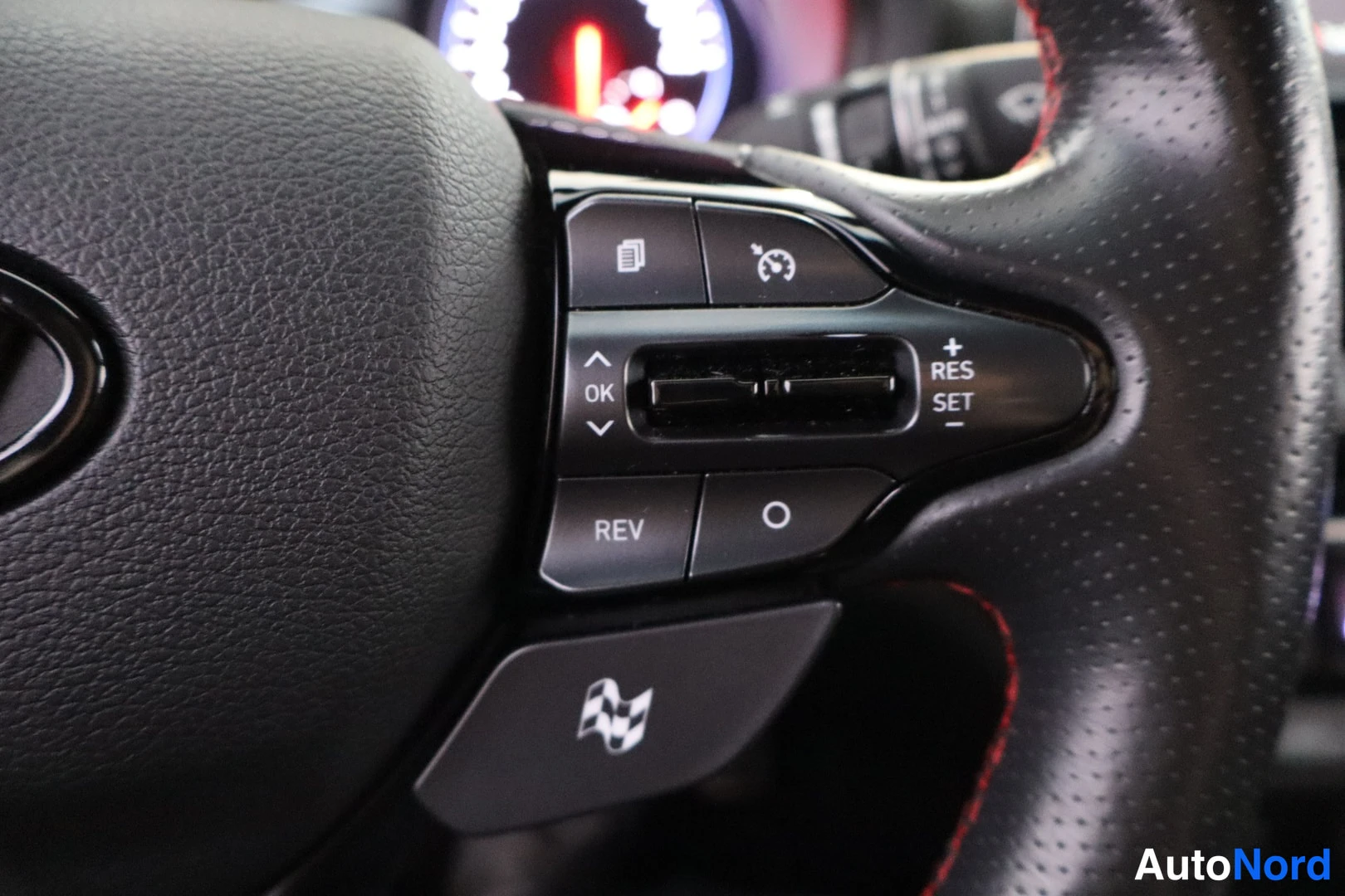 Etuviisto, nokka vasemmalle: Hyundaiin ohjauspyörän oikea puhelin: cruise control -näppäimet (RES/SET) ja alapuolella ruutulippulogo N Mode -nappi.