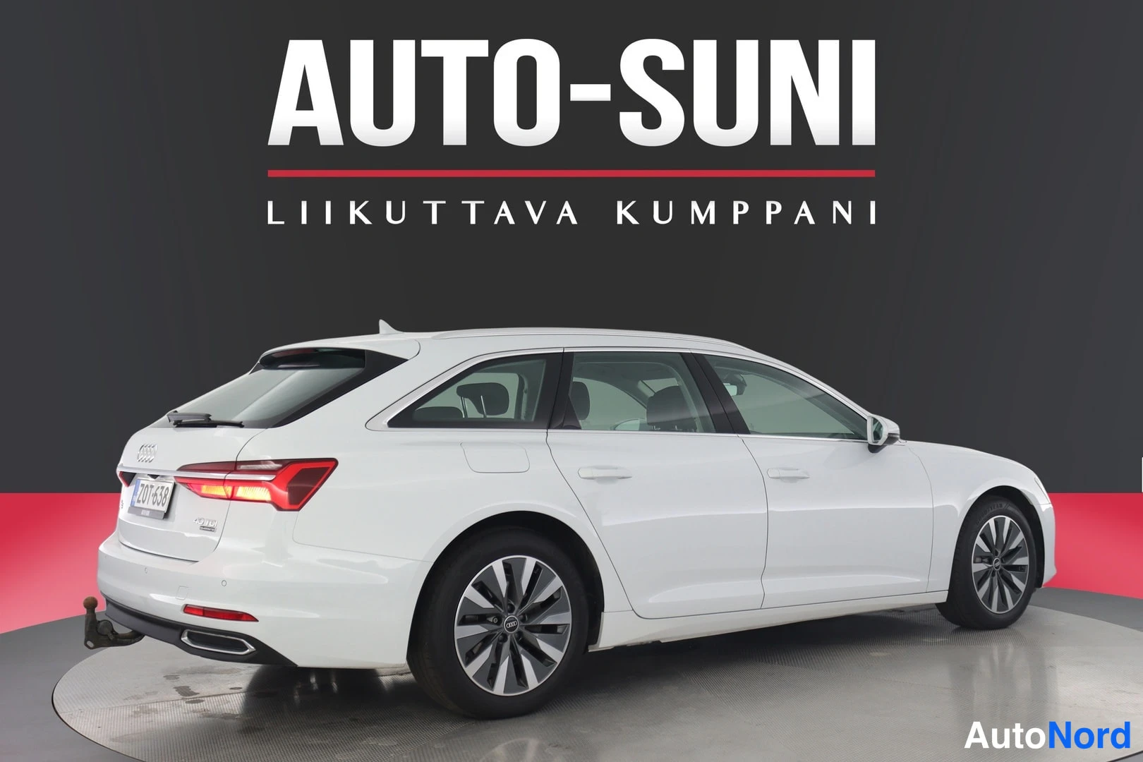 Takaviisto: Valkoinen farmariauto takakulmasta vasemmalta, punaiset takavalot ja rekisteritunnus.