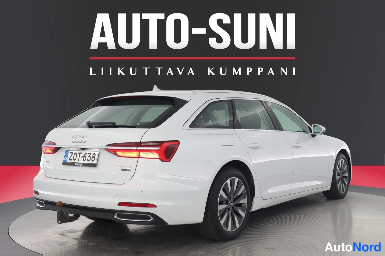 Takaviisto: Valkoinen farmariauto takaa vasemmalta, takavalot ja -kilpi, takaluukussa A6-merkintä.