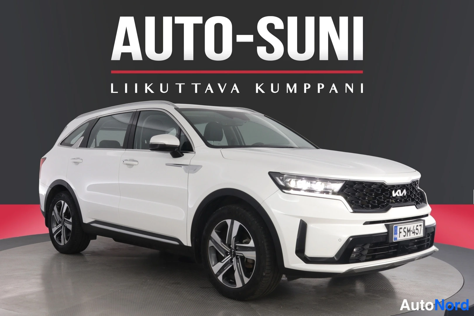 Etuviisto, nokka oikealle: Valkoinen Kia Sorento -maasturi kuvattu kolmeneljänneksestä edestä oikealta, rekisteritunnus, kuvassa näkyvät kohteliaat keulat ja viistoprofiili.