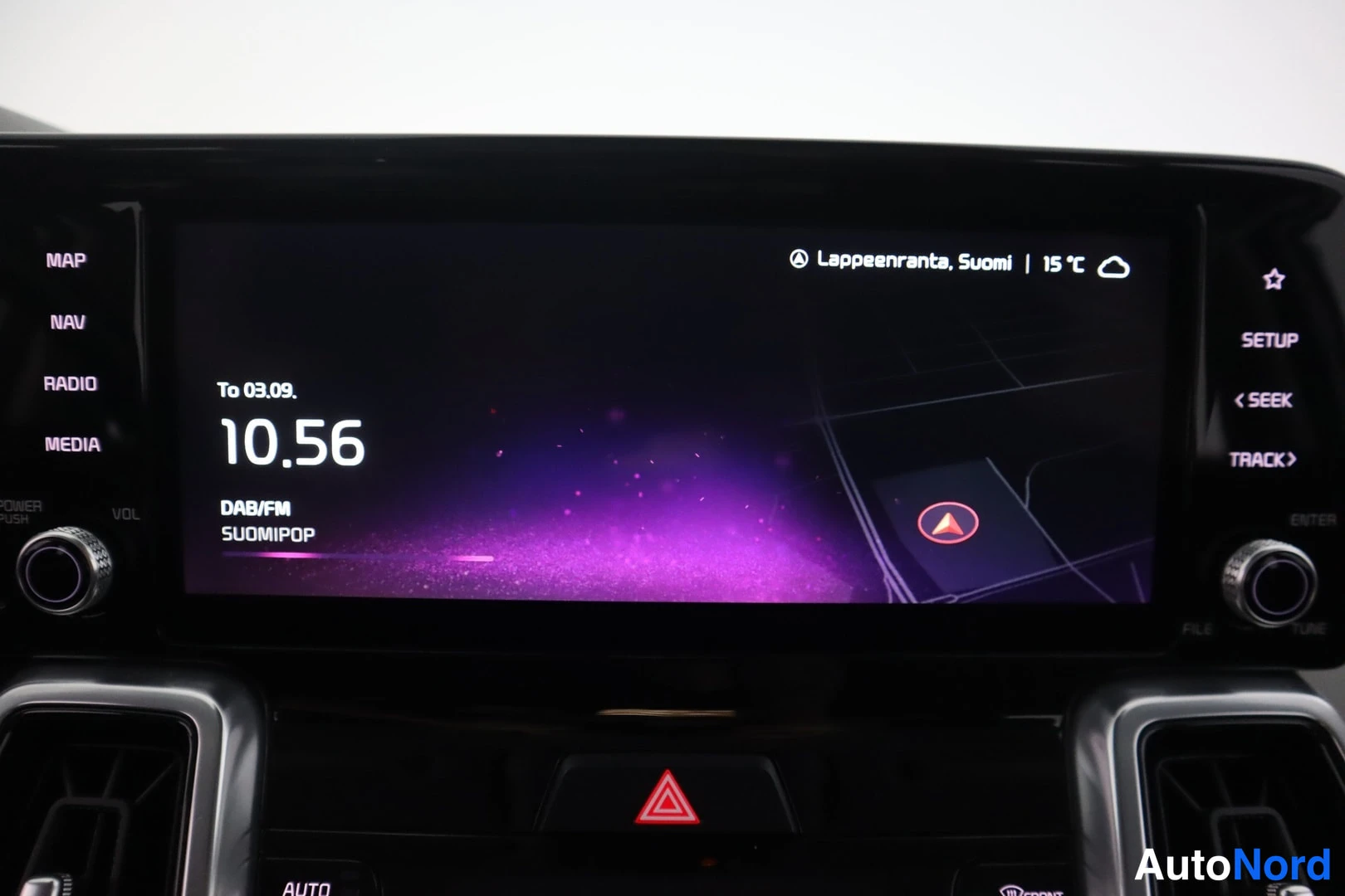 Yksityiskohta: Tiedoston auton radio- ja navigointinäyttö, jossa näkyy Lappeenranta, Suomi, kello 10.56 ja DAB/FM SUOMIPOP -kanava.
