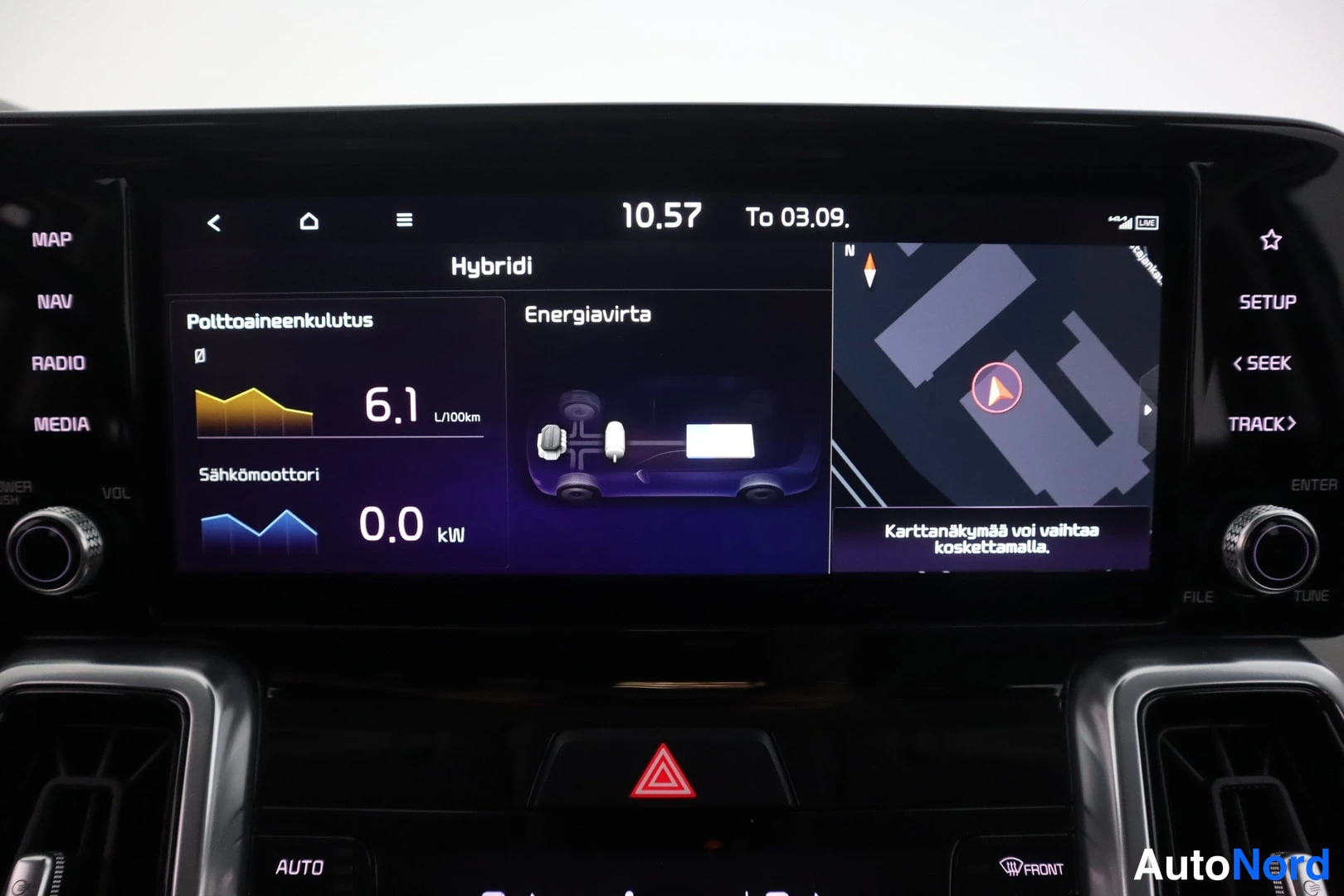 Muu: Hybridin energianvalvontanäyttö, jossa polttoaineenkulutus 6,1 l/100km ja sähkömoottorin teho 0,0 kW sekä navigointikartta oikealla.