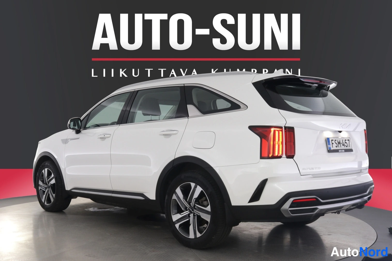 Takaviisto: Valkoisen Kia Sorento -maasturin takakulma oikealta, takavalot ja rekisteritunnus erottuvat, kuva otettu kuvastudiossa.