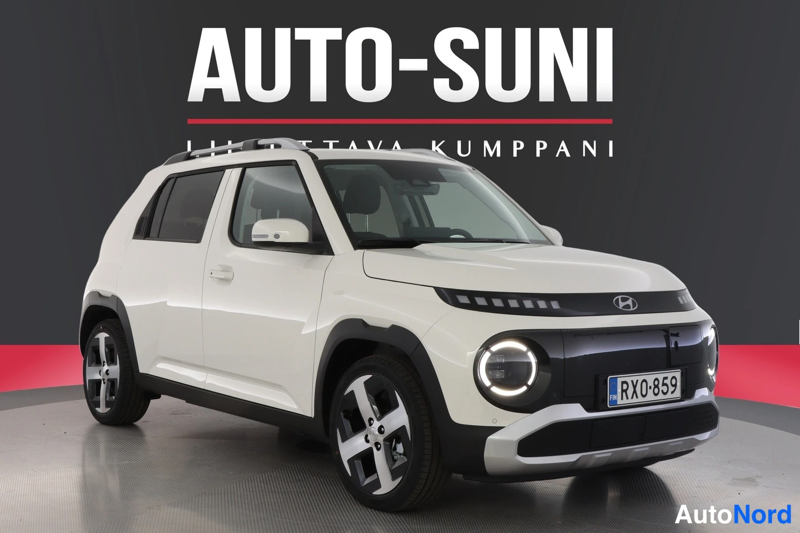 Etuviisto, nokka oikealle: White Hyundai INSTER shown from the front three-quarter angle with the grille and nose pointing towards the left. Visible details include LED headlight