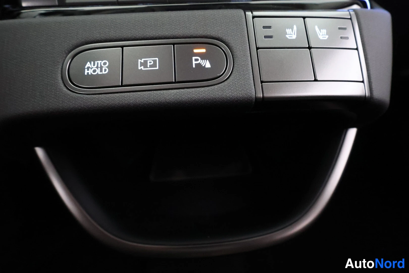 Yksityiskohta: Konsolin painikerivi: AUTO HOLD -painike, parkisojittimen (P) ja kääntötutkan (P) painikkeet sekä kaksi istuimen lämmityspainiketta, keltaiset merkkivalot sytty