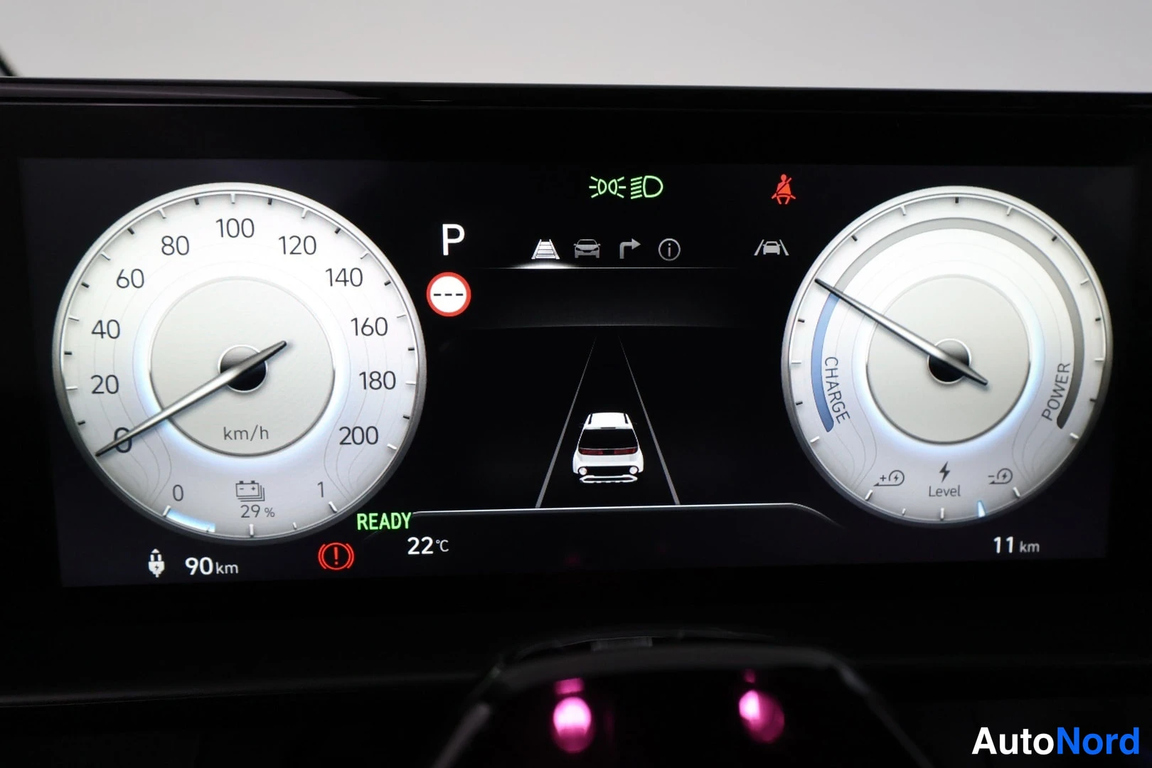 Muu: Digital instrument cluster display featuring two circular dials: speedometer on the left up to 200 km/h, battery power/charge gauge on the right. Center screen