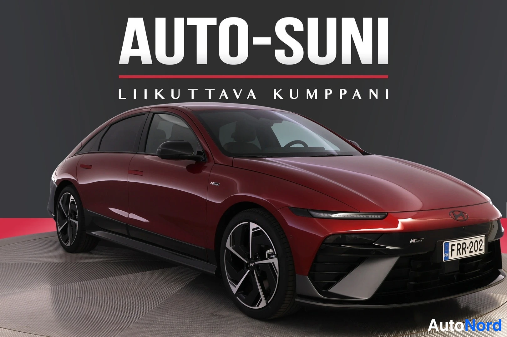 Etuviisto, nokka oikealle: Punainen auto kolmeneljännesronttinäkymässä, etusäiliö oikealla.