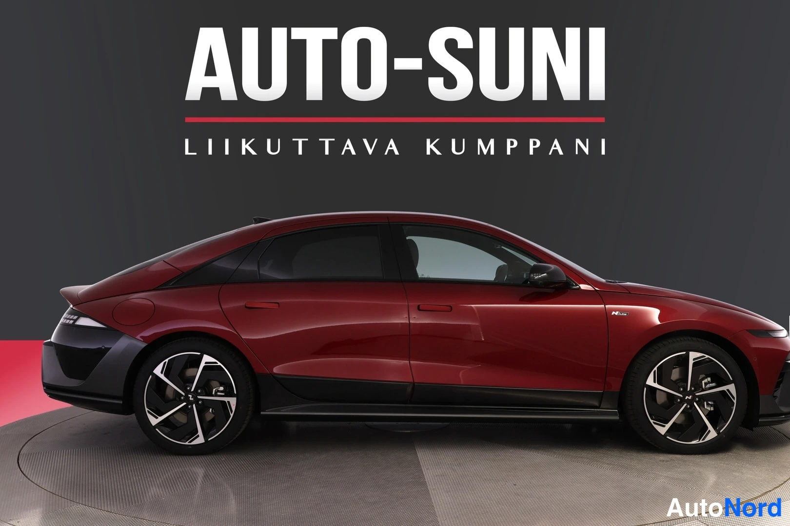 Sivulta: Punaisen auton sivunäkymä, kylki kokonaan kuvassa.