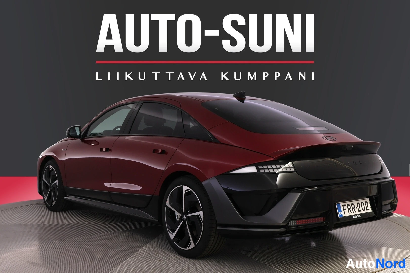 Takaviisto: Punaisen auton takakolmeneljännesnäkymä toisesta kulmasta, rekisterikilpi.