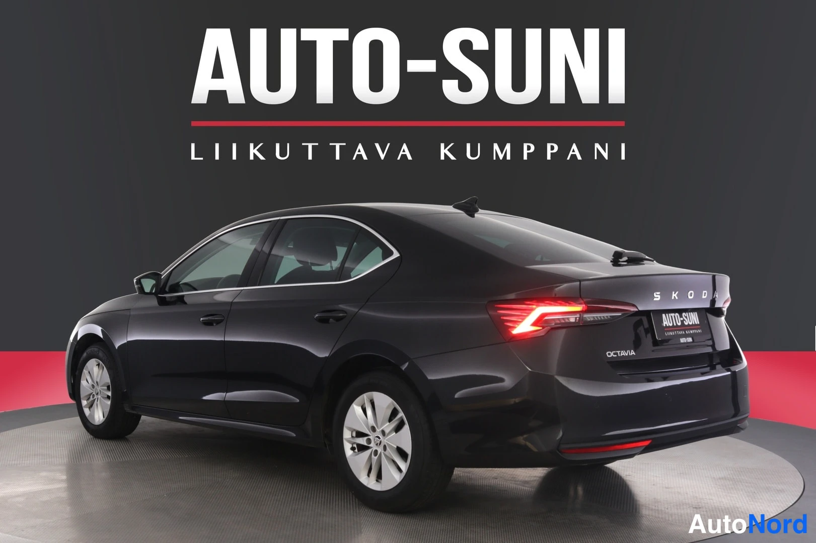 Takaviisto: Auton takakulma vasemmalta: musta neliovinen sedan, takaosassa näkyy OCTAVIA-teksti ja takavalo.