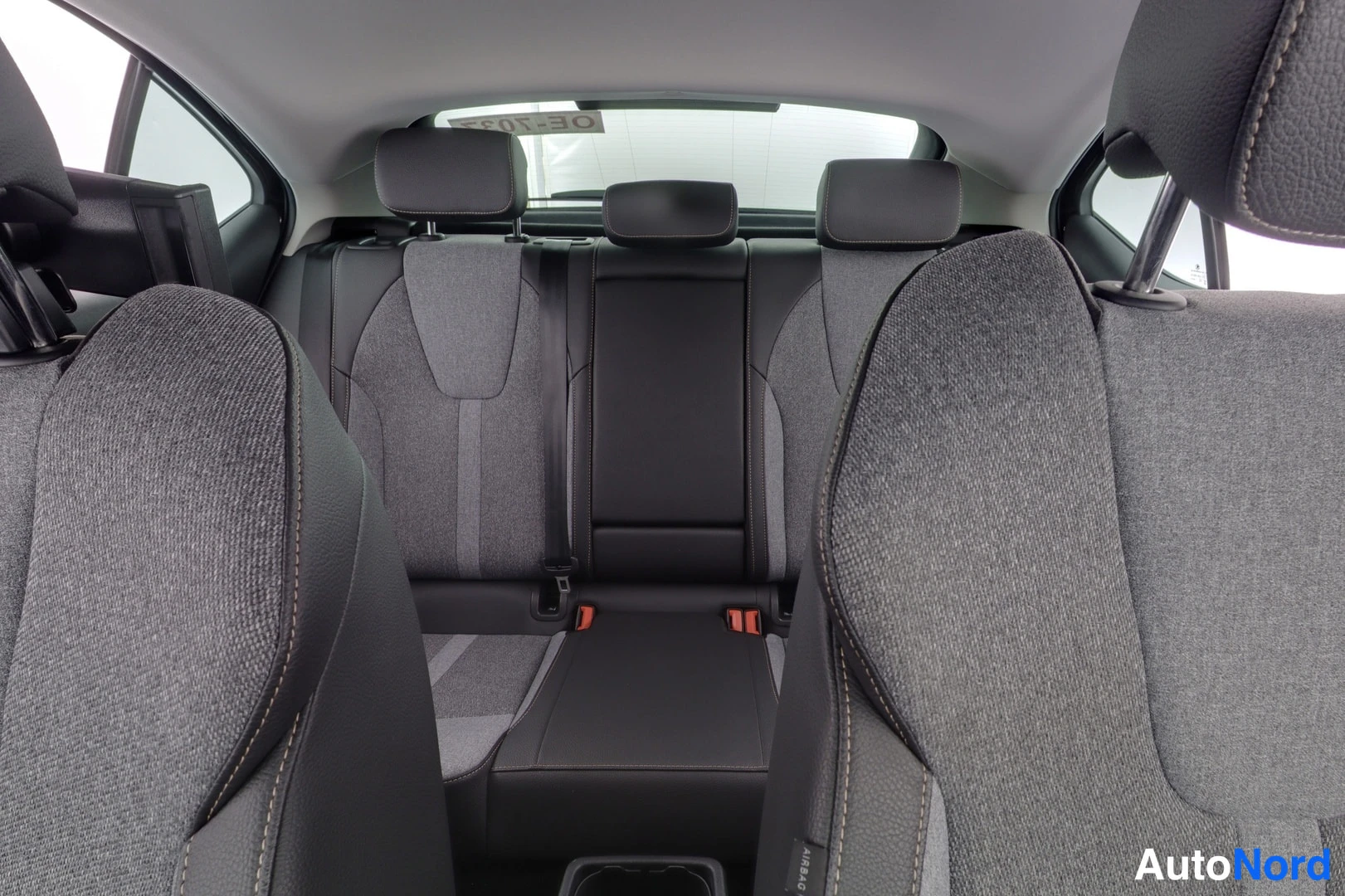 Takaistuimet: View of rear seating area from the front looking back, showing three rear headrests and ISOFIX points.