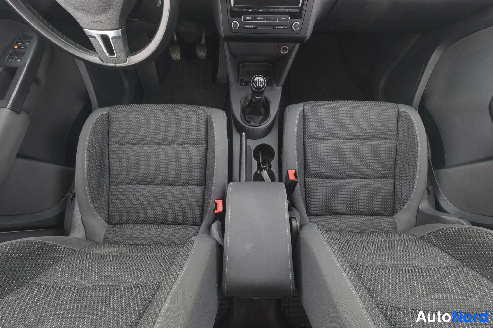 Etuistuimet: Front view of gray cloth front seats and center console with gear stick