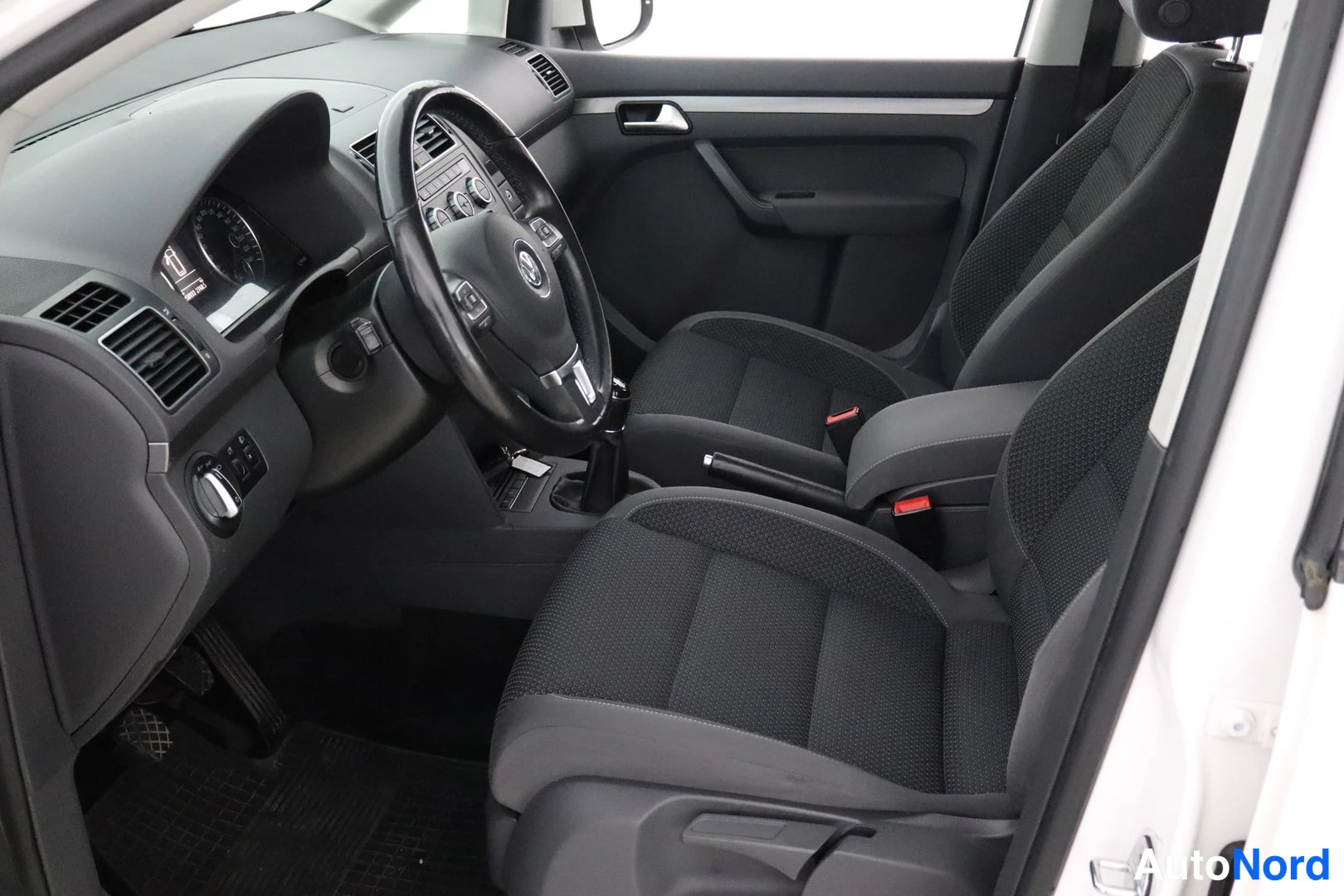 Ohjaamo: Left side interior shot showing steering wheel, dashboard, and two front seats