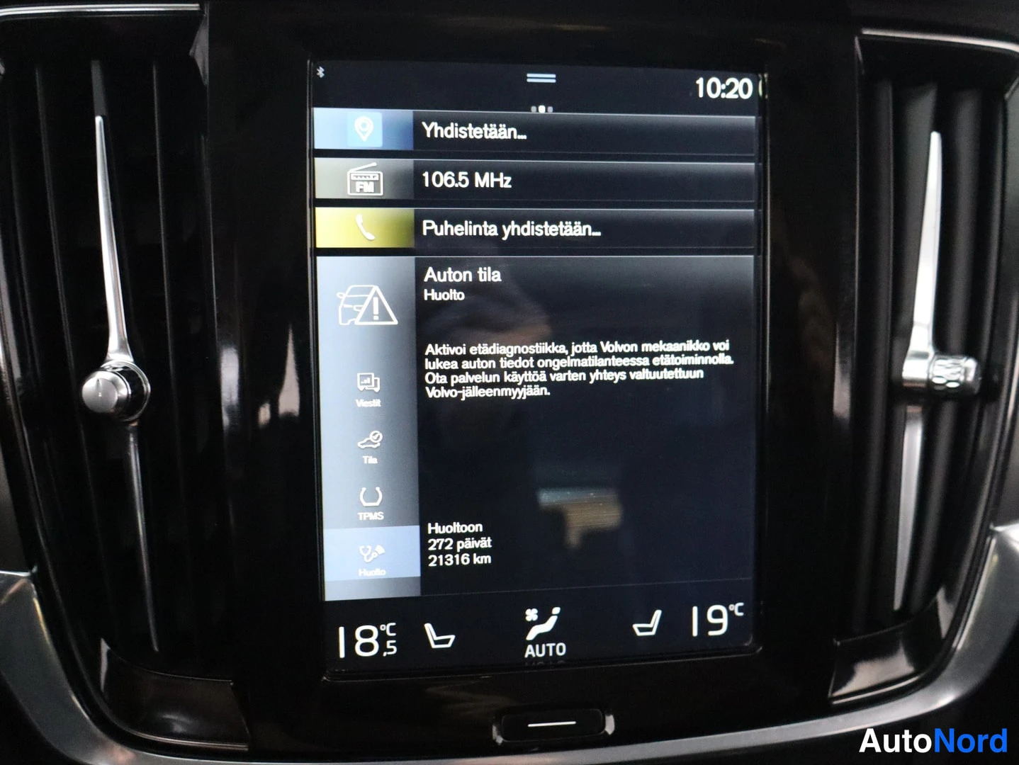 Ohjaamo: Close-up of vertical infotainment screen showing maintenance information in Finnish. Header reads 'Auton tila Huolto' (Car status Maintenance). Text explains ac