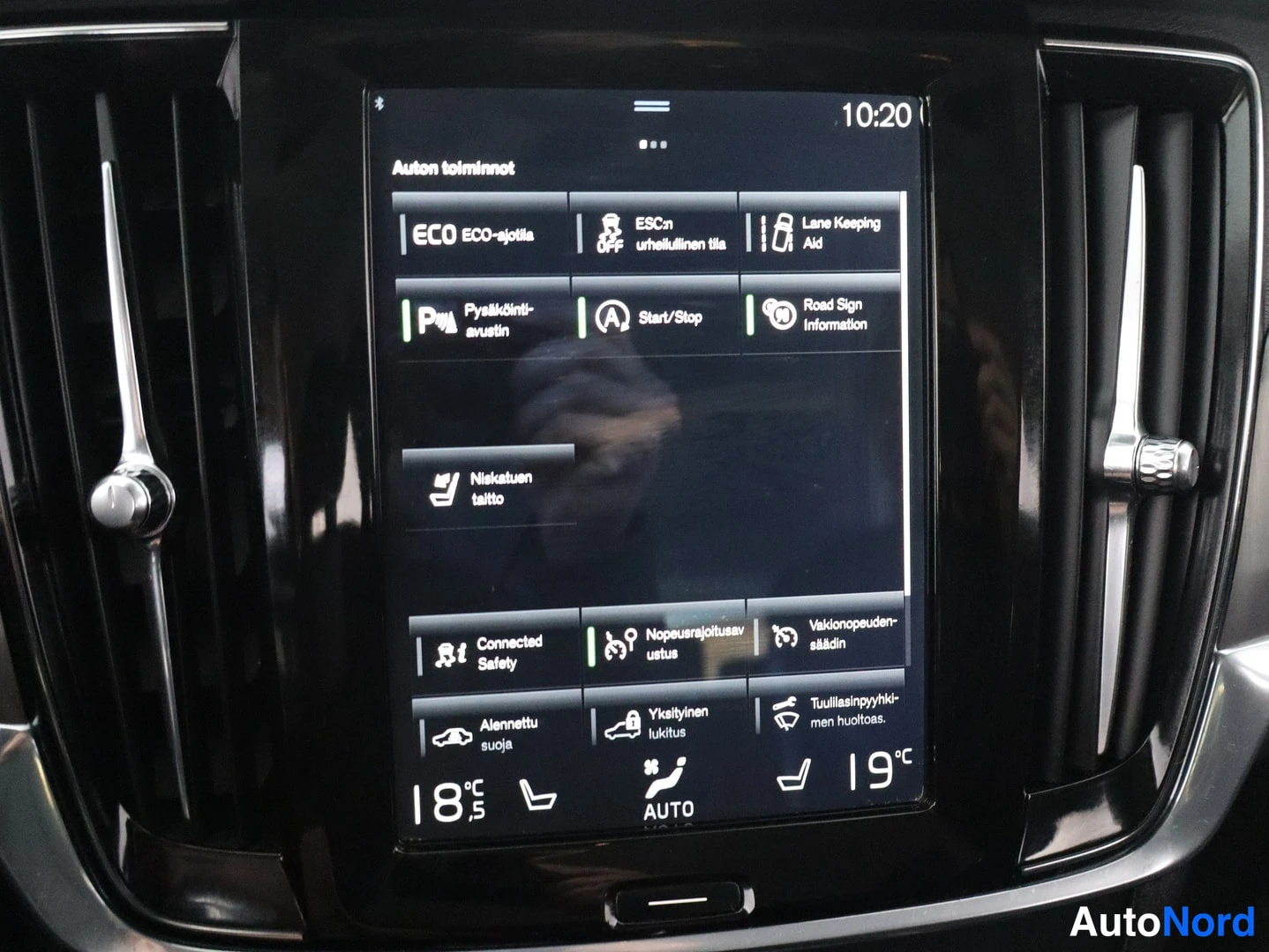 Ohjaamo: Vertical infotainment touchscreen displaying vehicle functions menu titled 'Auton toiminnot' (Car functions). Icons include Lane Keeping Aid, Start/Stop, Road S