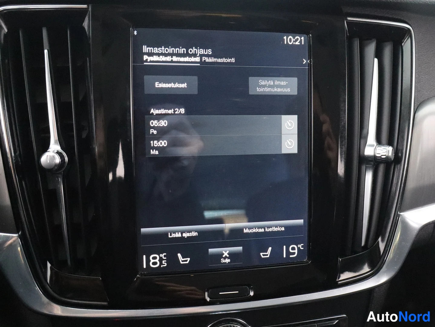 Yksityiskohta: The touchscreen infotainment screen shows an air conditioning control interface in Finnish with temperature settings.