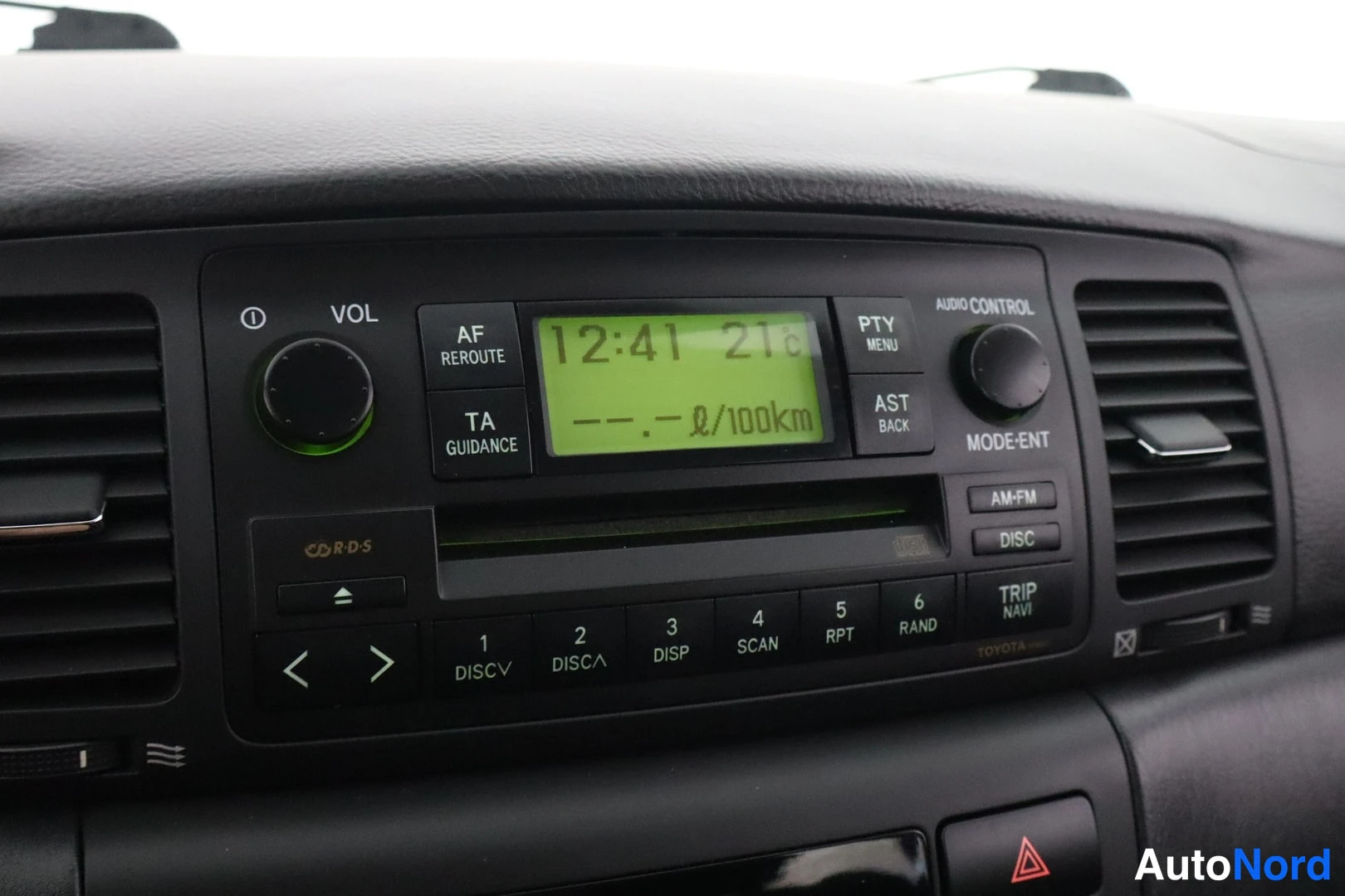 Yksityiskohta: Auton kojelaudan radiolinja CD-RDS-soittimella, näytöllä aika 12:41 21.6 ja --.- l/100km.