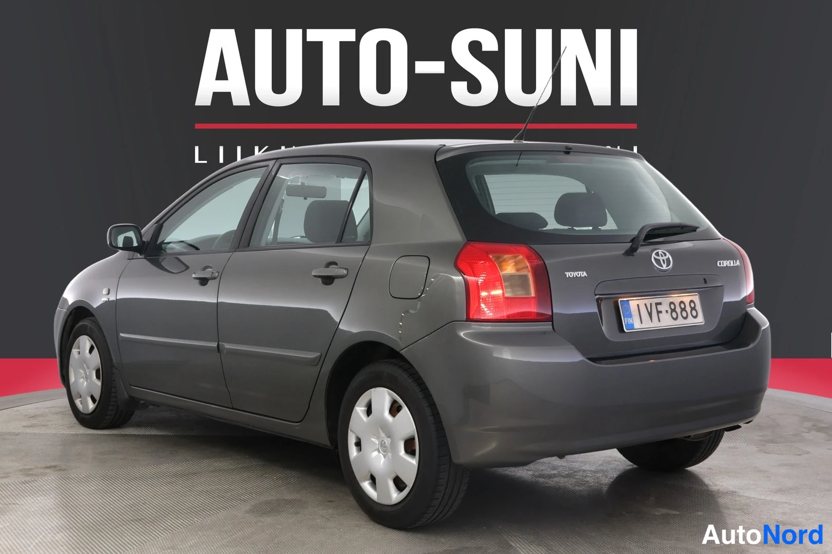 Takaviisto: Kuvassa harmaanharmaa Toyota Corolla -auton taka-oikea kulma. Rekisterikilpi, Toyota-logot ja 'COROLLA' -teksti ovat nähtävissä autossa.