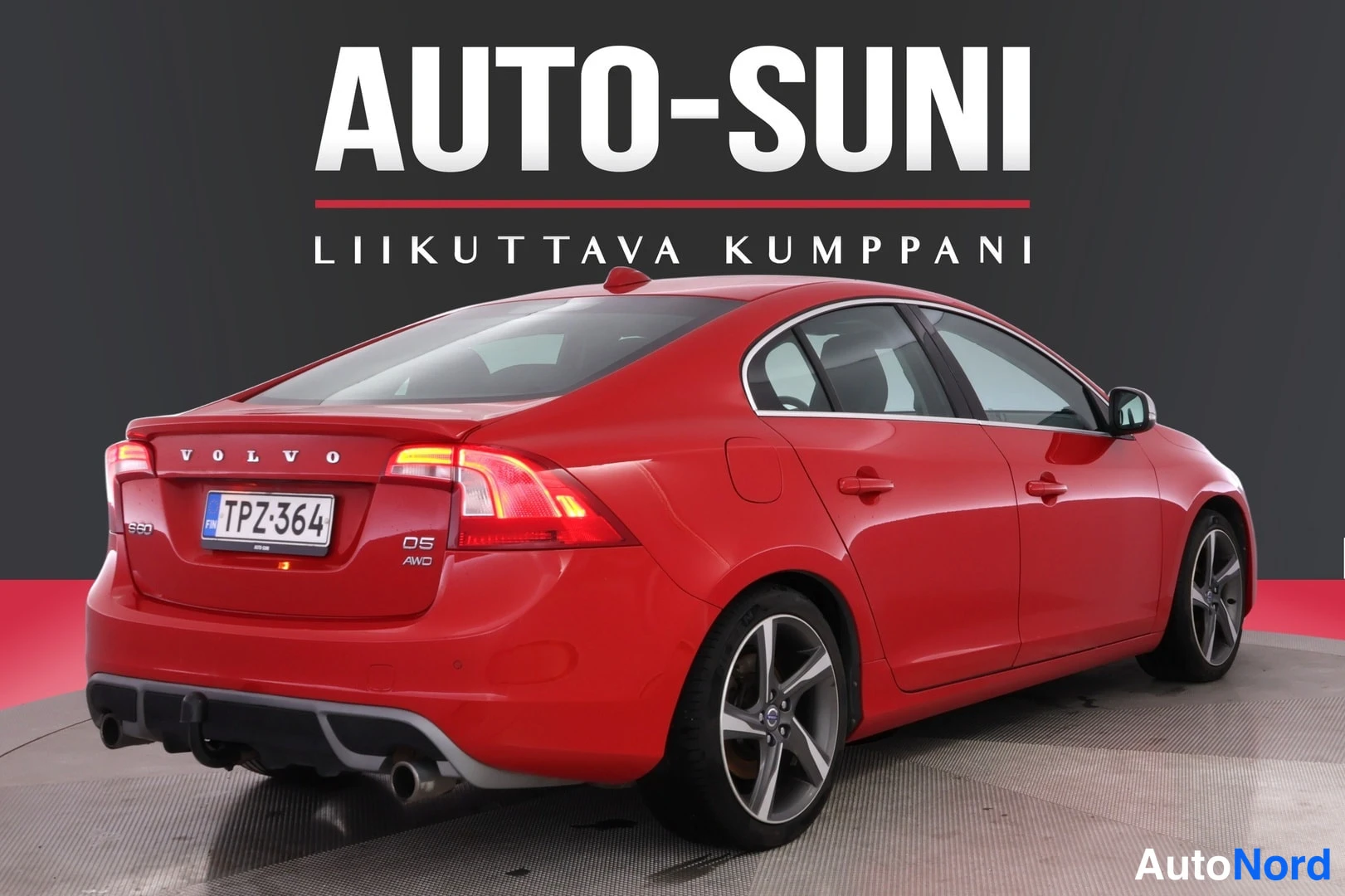 Takaviisto: Punainen sedan takaa oikealta, takavalo ja rekisteritunnus näkyvissä.
