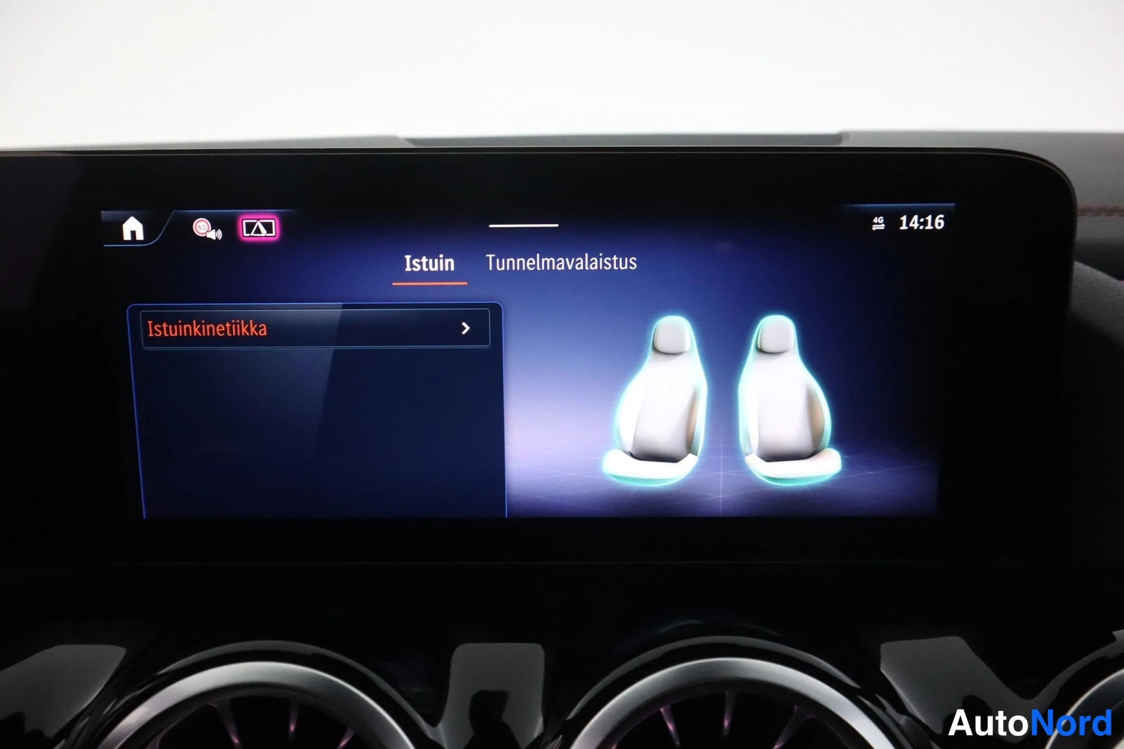 Muu: Infotainment-näytön Istuin-valikko, jossa Istuinkiinettiikka-vaihtoehto ja kaksi istuinta esittävää kuvaa Tunnelmavalaistus-välilehden vieressä.