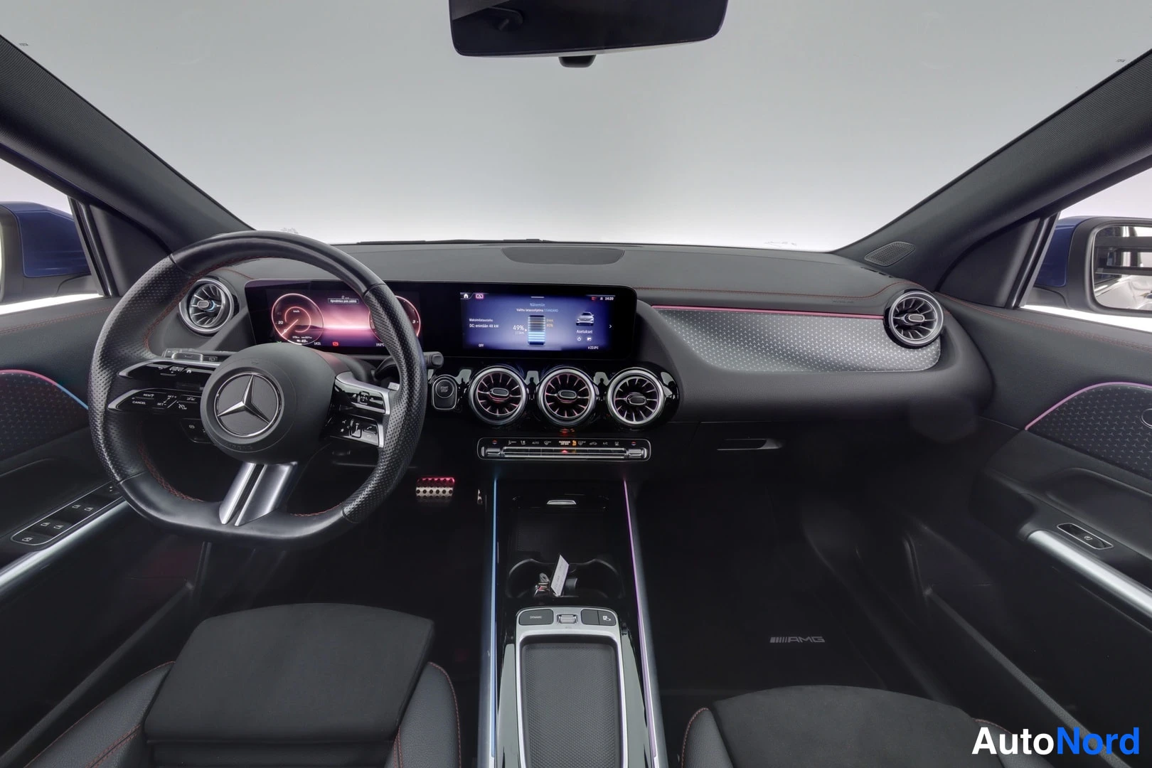 Ohjaamo: Interior cabin shot showing the dashboard, digital instrument cluster, dual-screen infotainment display, and multifunction steering wheel with red contrast stit