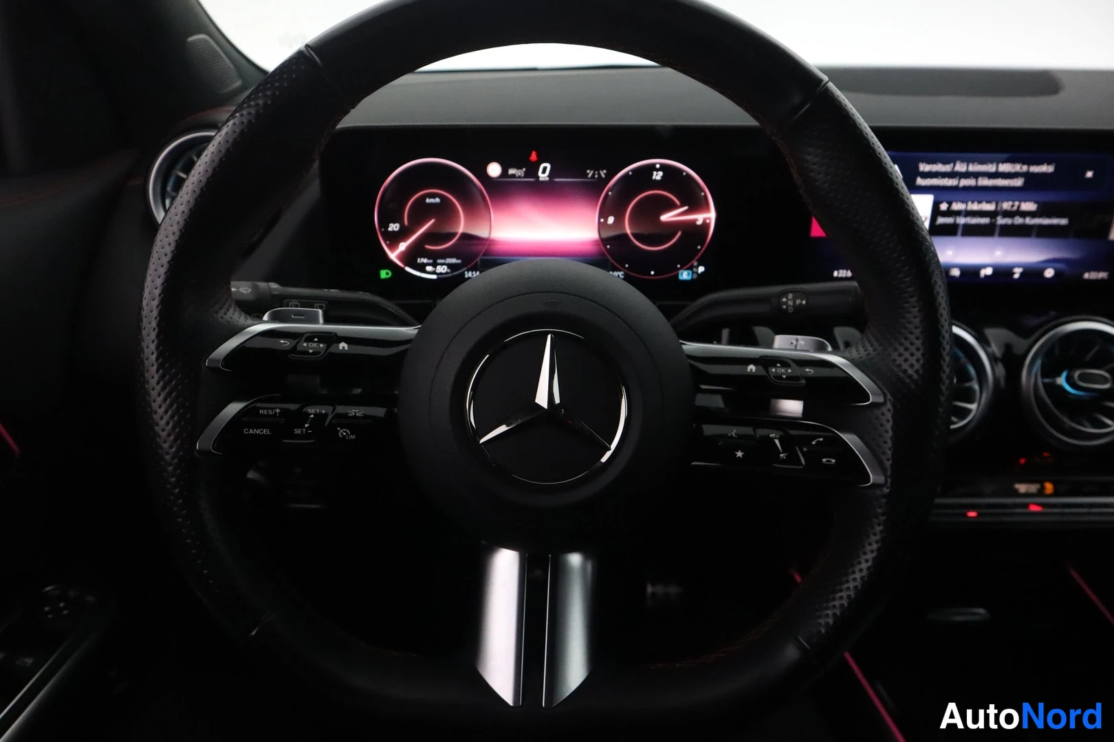 Sivulta: Mercedes-tähdellä varustettu nahkainen ohjauspyörä ja digitaalinen mittaristo, nopeus 0 km/h.
