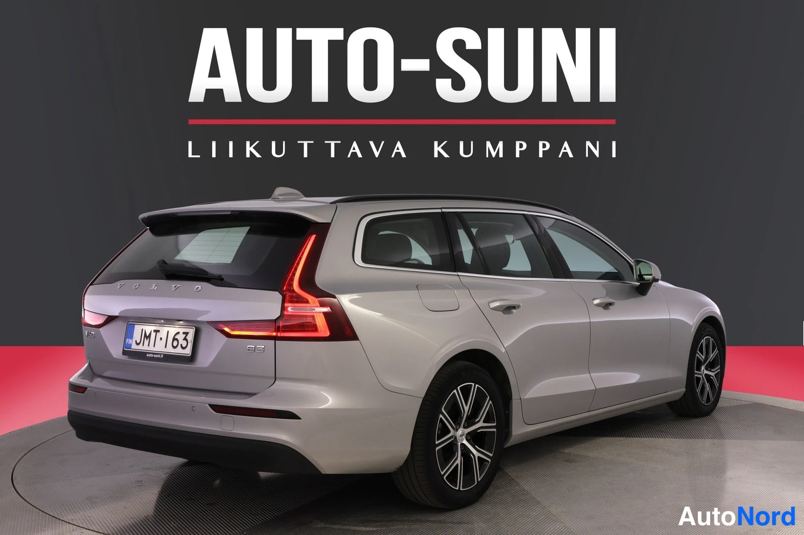 Takaviisto: Auton takaosa ja oikea sivu vinosti takaa; hopeanharmaa farmariauto, rekisteri.