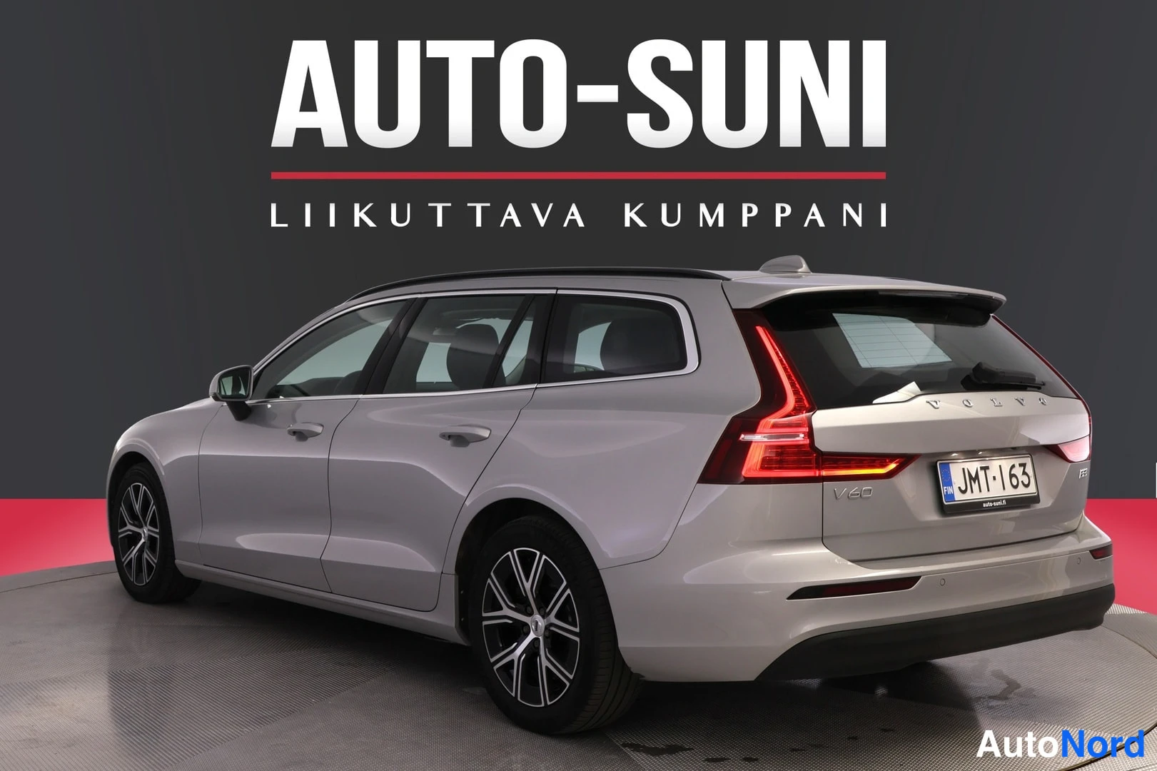 Takaviisto: Auton takaosa ja vasen sivu vinosti takaa; hopeanharmaa farmariauto, rekisteri.