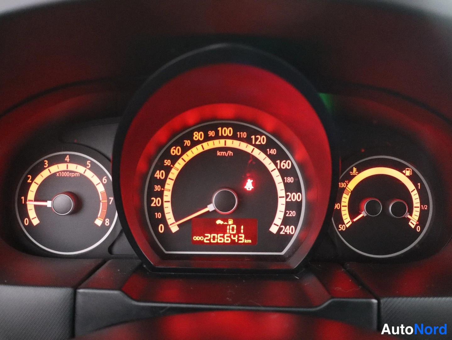 Muu: Kia-mallin mittaristo, nopeusmittari asteikolla 0-240 km/h, matkamittari 206 643 km, varoitusvalo sytyksessä.