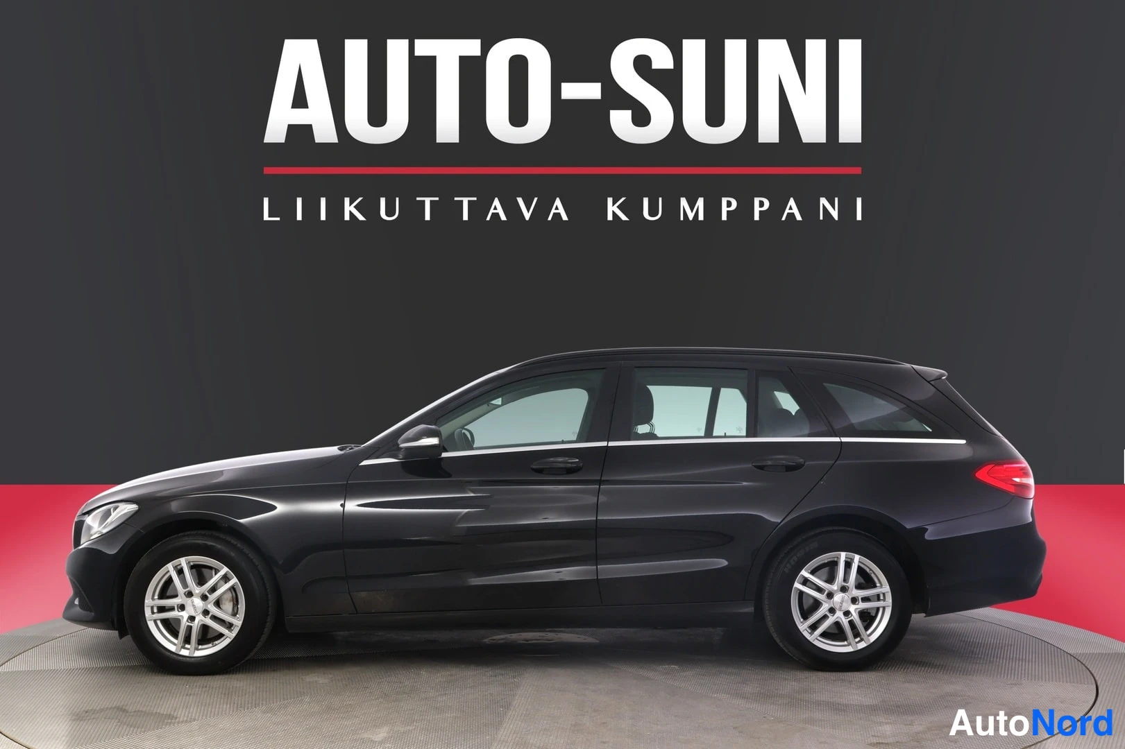 Sivulta: Mustan farmariauton sivuprofiili studio­taustaa vasten, AUTO-SUNI mainosteksti yläpuolella.