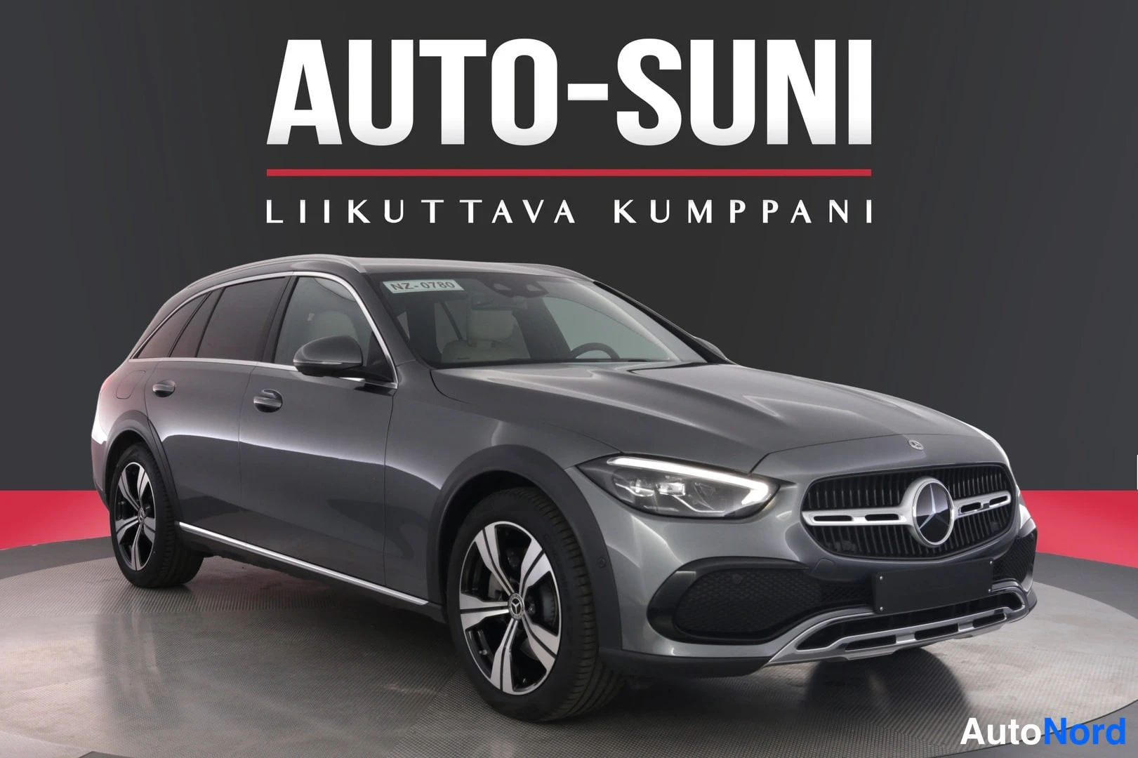 Etuviisto, nokka oikealle: Auton etukulma ja sivu näkyvät; kori on harmaa. Kuvassa näkyvät etusäleikkö, Mercedes-tähti, ajovalot, konepelti ja vasemman puolen ovet ja pyörät.