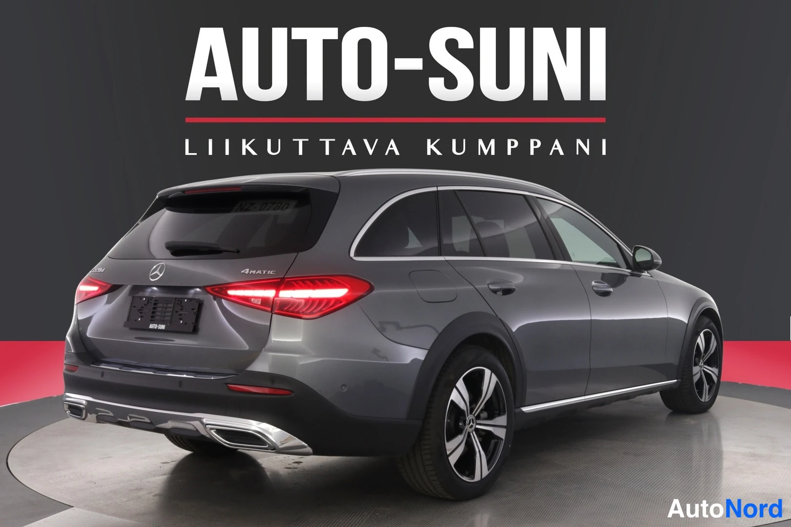 Takaviisto: Auton takakulma ja oikea sivu näkyvät; kori on harmaa. Näkyvät takavalot, avattava takaikkuna, takapuskuri, pakoputket ja pyörät.