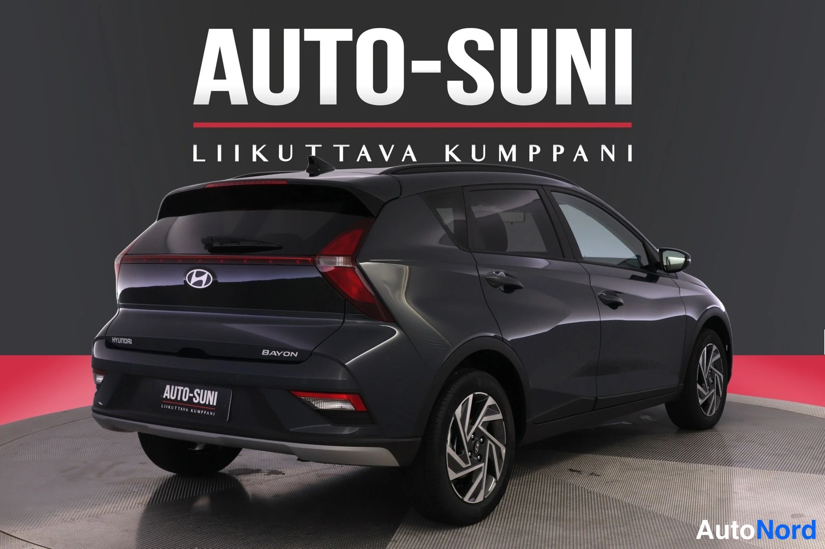 Takaviisto: Hyundai Bayon -henkilöauto takaa vasemmalta kolmannelta kulmalta kuvattuna studiossa; takaluukussa Bayon-merkintä.