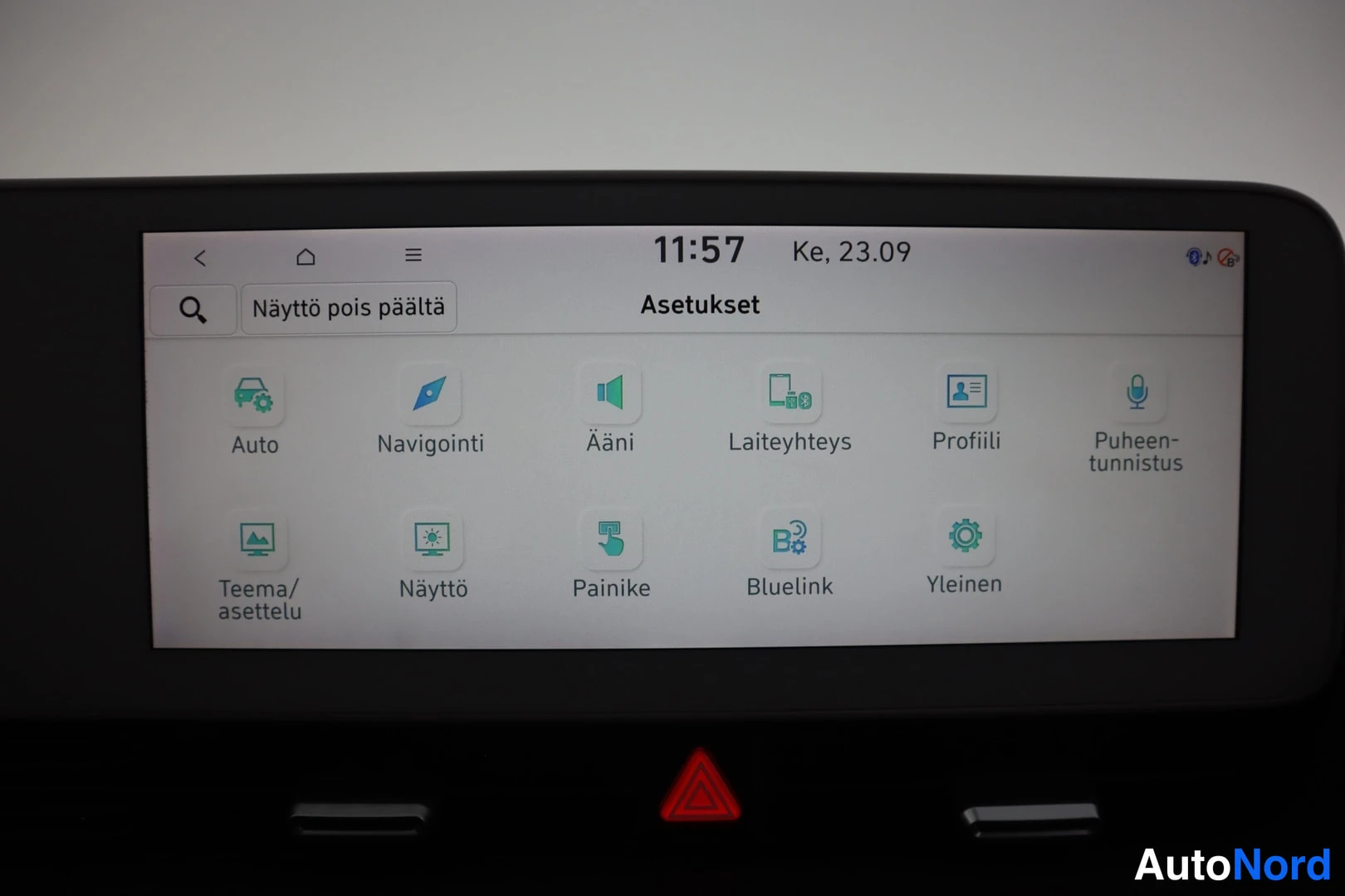 Muu: Infotainment-näyttö, jossa Asetukset-valikko vaihtoehdoilla Auto, Navigointi, Ääni, Laiteyhteys, Profiili, Puheentunnistus, Teema/asettelu, Näyttö, Painike, Blu