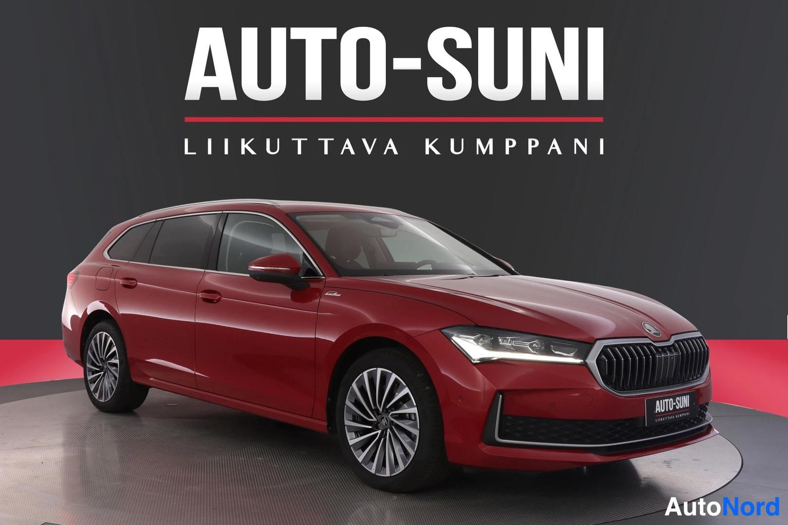 Etuviisto, nokka oikealle: Punainen farmariauto kuvattu kolmannelle siten, että keulan etusäleikkö ja ajovalot sekä oikea kylki näkyvät.