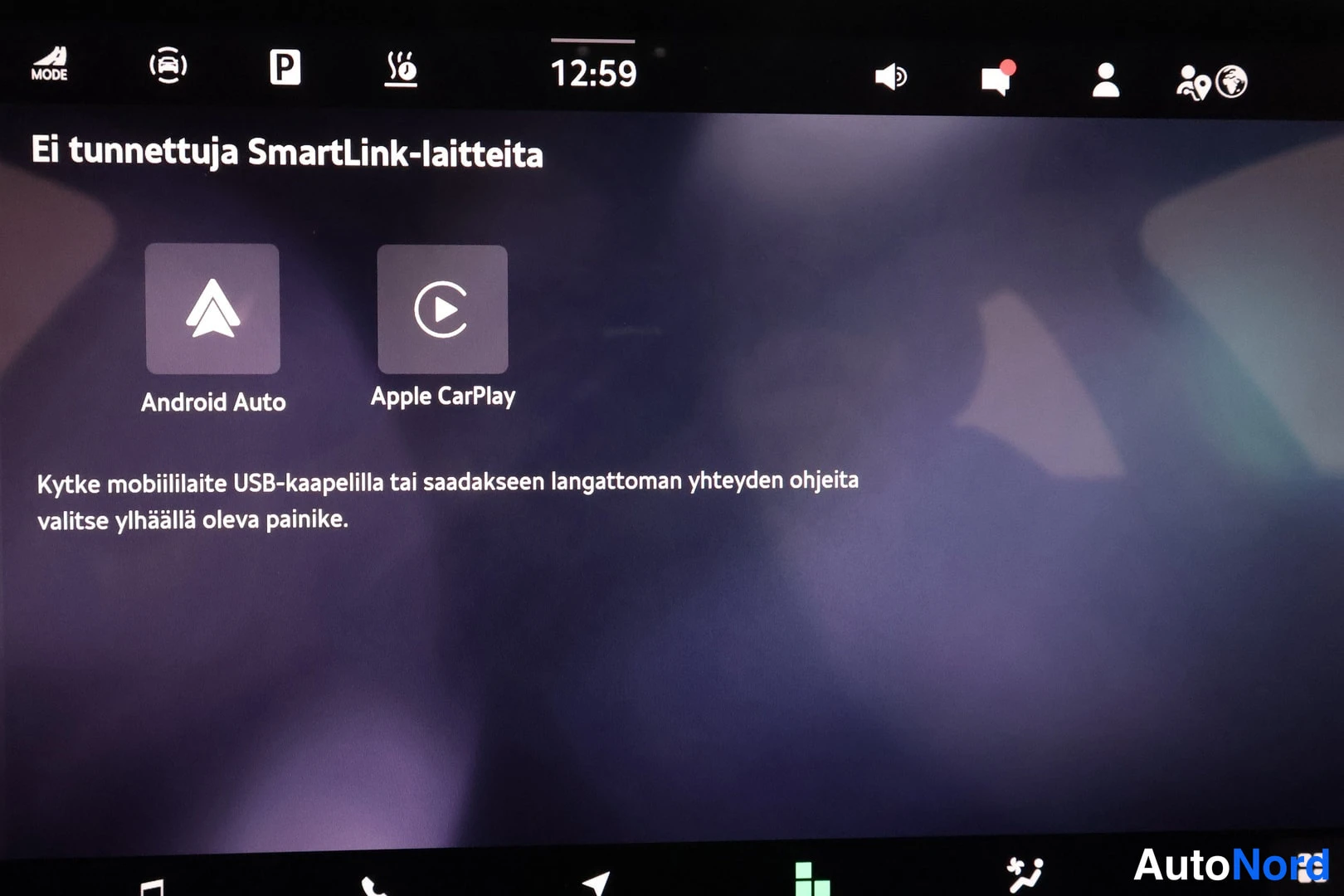 Yksityiskohta: auton infotainment-näyttö SmartLink-näkymässä, jossa lukee 'Ei tunnettuja SmartLink-laitteita' sekä Android Auto- ja Apple CarPlay-kuvakkeet; kello näyttää 12:5