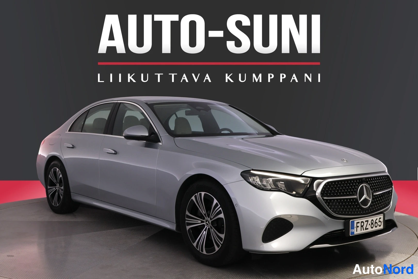 Takaa: Hopeanvärinen sedan etuviistosta oikealta: etusäleikkö Mercedes-tähdellä, rekisterikilpi, monipolviset kevytmetallivanteet.