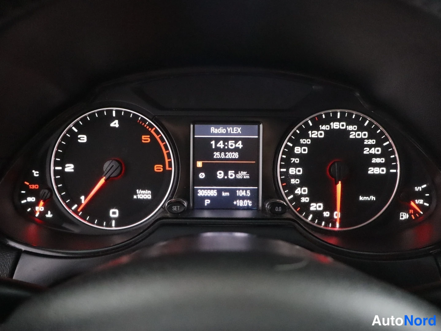 Edestä: Mittaristo lähikuvassa: nopeusmittari asteikolla jopa 280 km/h, tietonäytössä Radio YLEX, 305565 km ja +19.0°C.