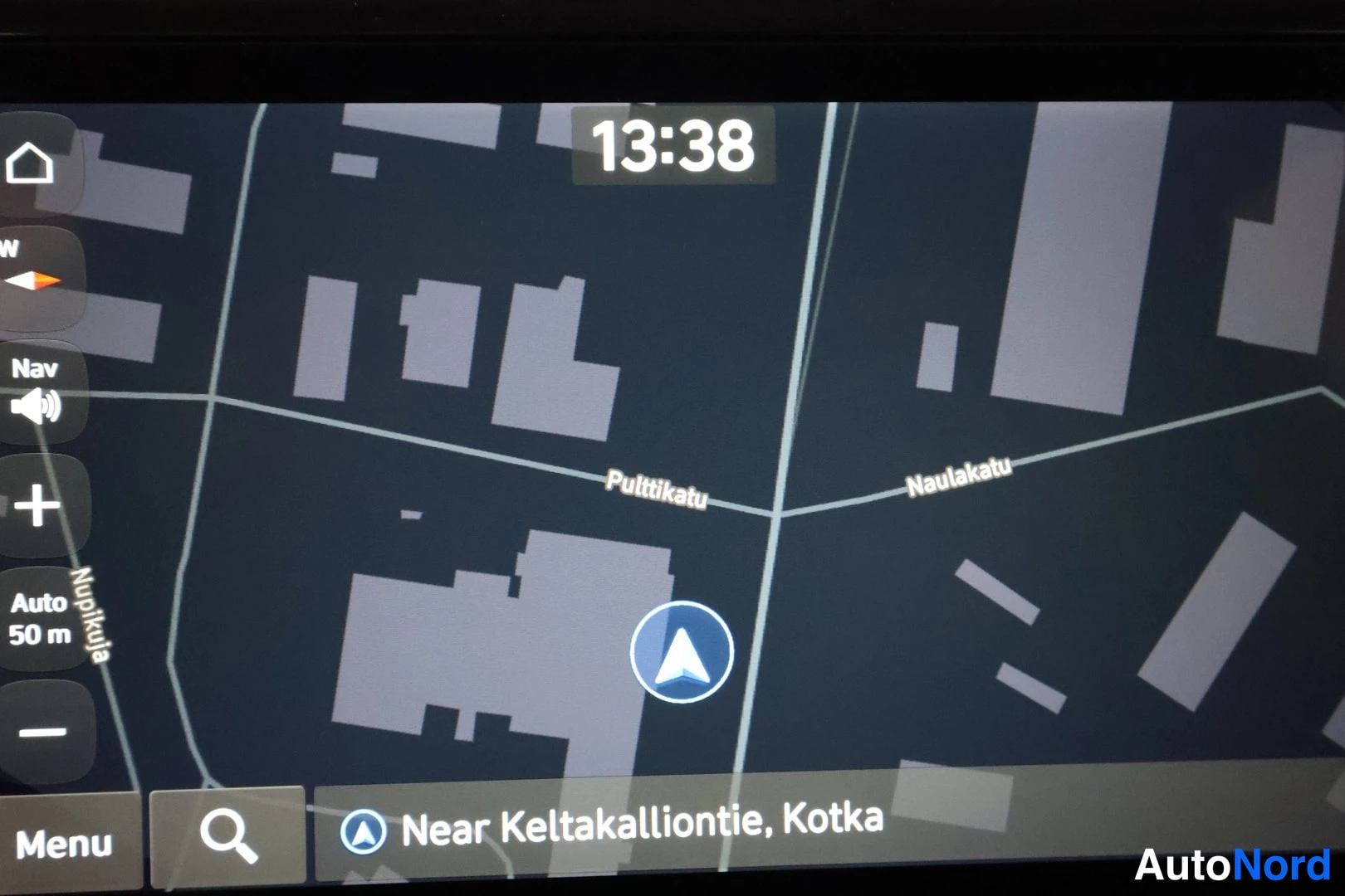 Muu: Auton navigointinäyttö: kartta Kotkan alueella, kello 13:38, hakupainike ja Menu-painike alareunassa, sivupainikkeet Nav, Auto 50 m ja Nupikula.