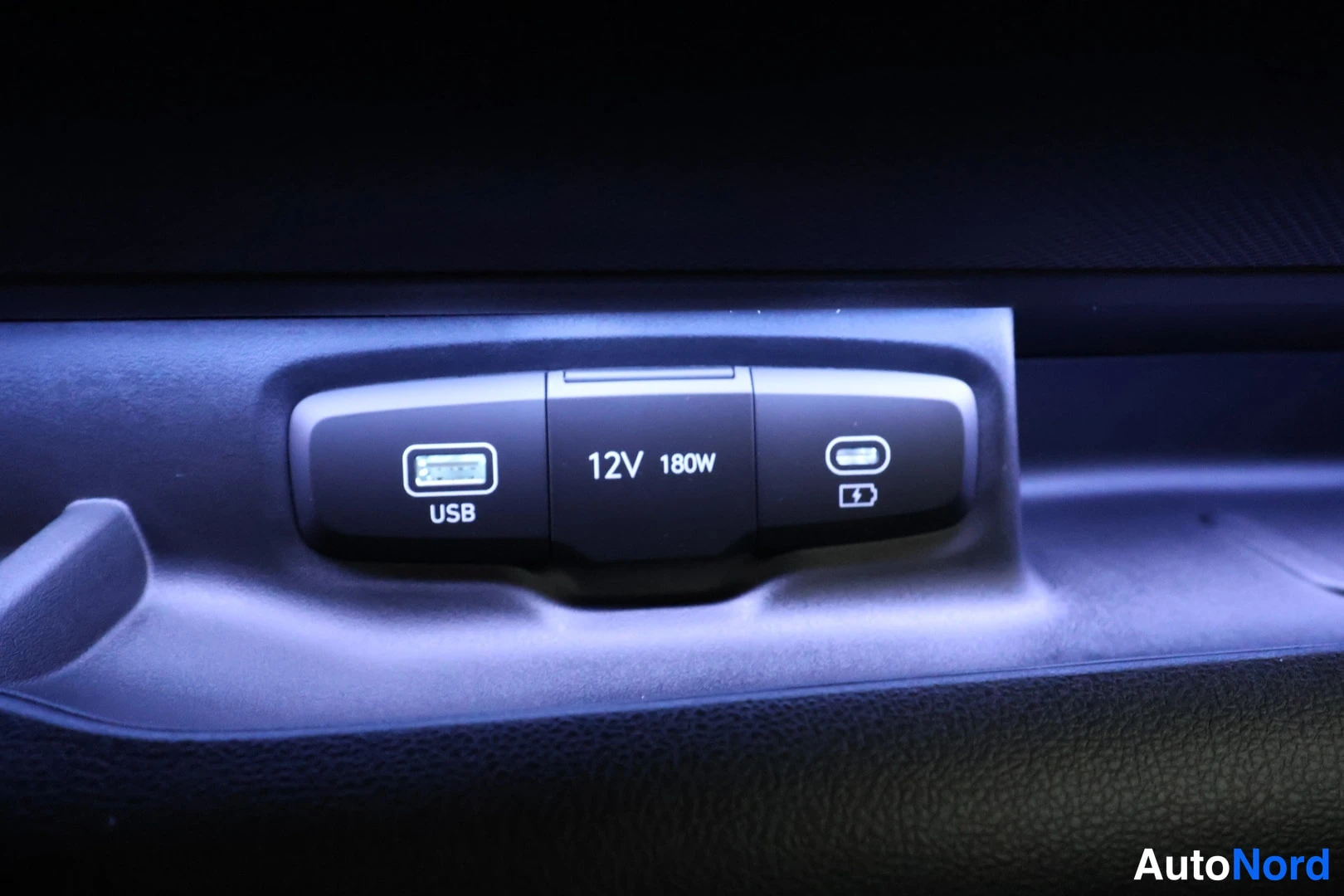 Yksityiskohta: Kojeiston alla olevat liitännät: USB-portti ja 12V 180W -pistorasia.