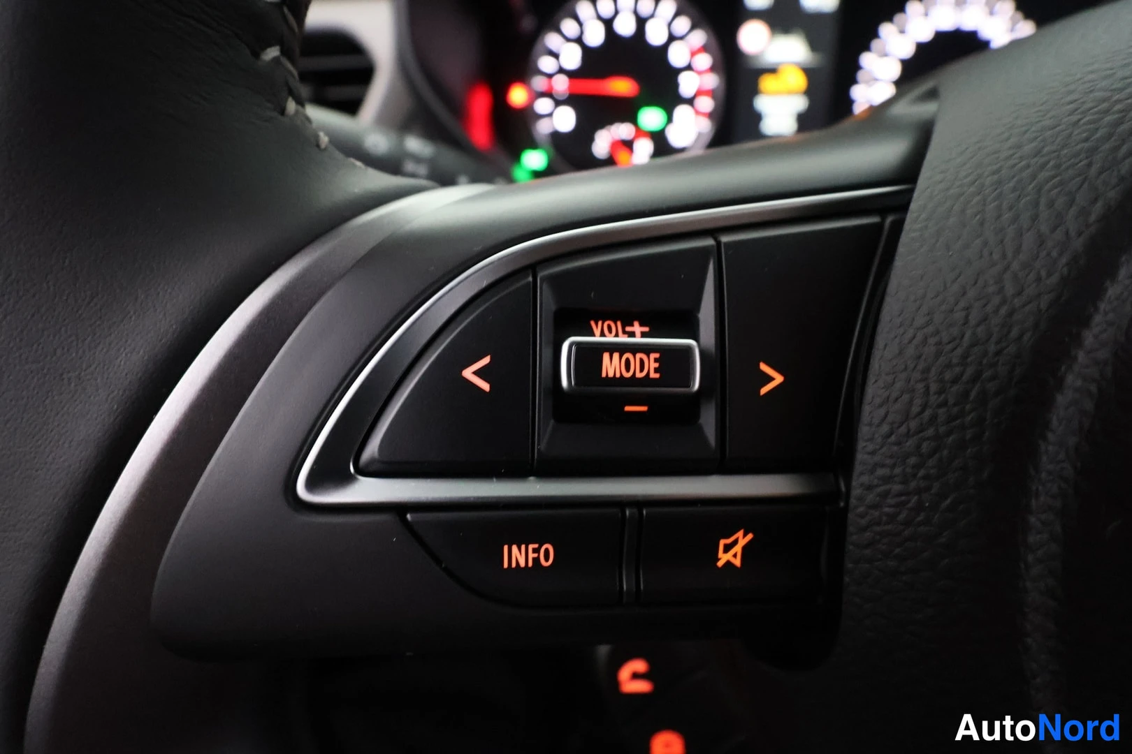 Muu: Suzuki Swift, kuva 0: Ohjauspyörän näppäimet MODE, VOL, INFO ja stabilointiohjaimen symboli, taustalla mittaristo.
