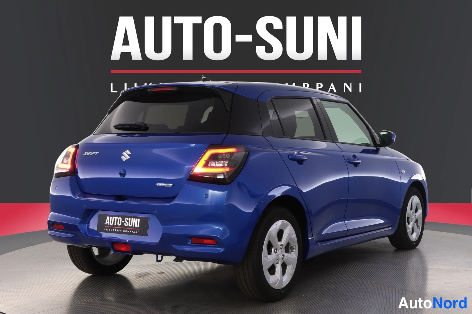 Takaviisto: Sininen Suzuki Swift -henkilöauto takaa viistosti kuvattuna.
