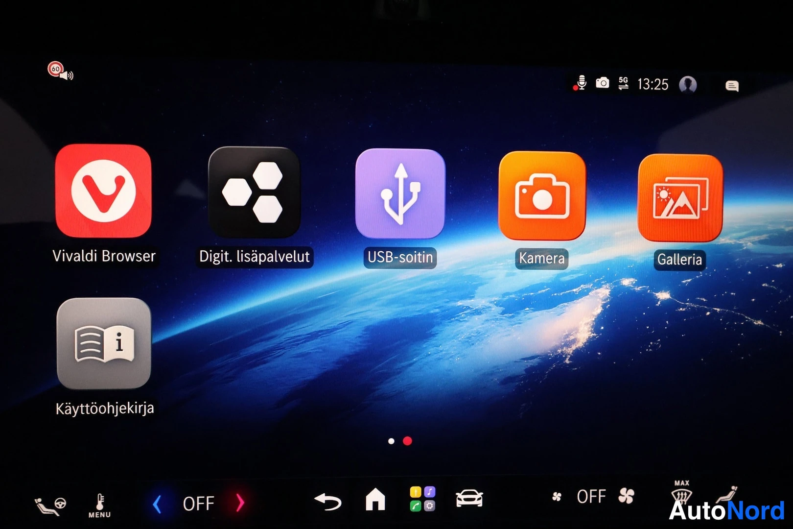 Yksityiskohta: Auton infotainment-näytön sovellusnäkymä: ruudulla Vivaldi Browser, Digit. lisäpalvelut, USB-soitin, Kamera, Galleria ja Käyttöohjekirja -kuvakkeet sekä kellona