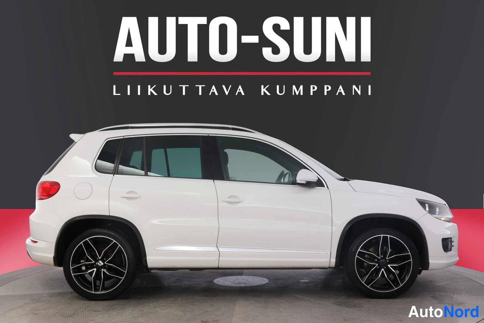 Etuviisto, nokka oikealle: Valkoinen Volkswagen Tiguan sivulta oikealta nähtynä, tummat vanteet ja kattokaiteet.